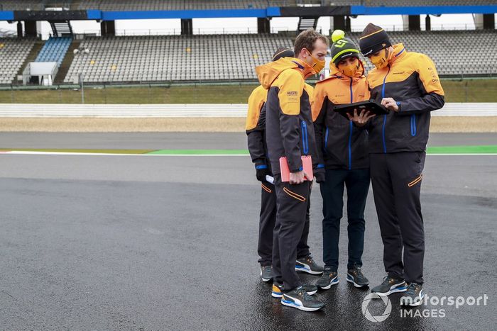 Lando Norris, McLaren, recorre la pista con miembros del equipo