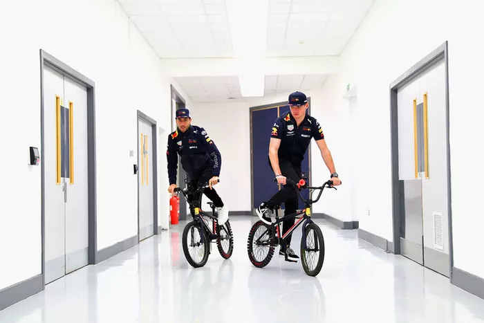 Max Verstappen, Red Bull Racing, y Daniel Ricciardo, Red Bull Racing, montan bicicletas en la fábrica