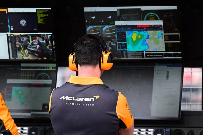 Un ingeniero de McLaren echa un vistazo al radar meteorológico en el muro de boxes