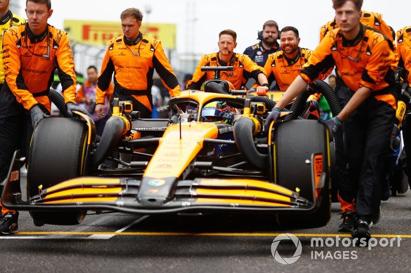I meccanici della McLaren spingono la vettura di Oscar Piastri, McLaren MCL38, verso il suo posto in griglia di partenza