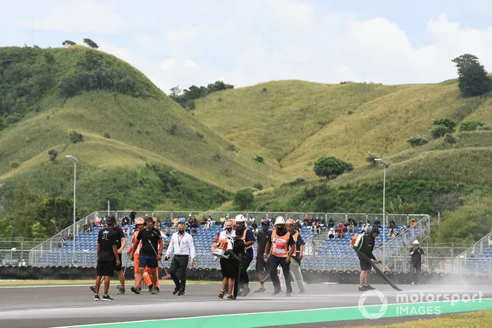 Comisarios limpiando después del fuego en la moto de Alex Rins
