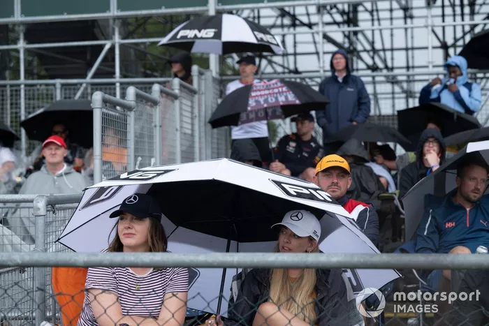 Aficionados bajo paraguas en una tribuna