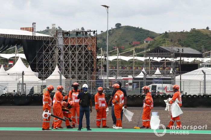 Comisarios limpiando después del fuego en la moto de Alex Rins
