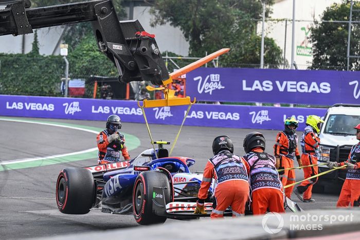 Los comisarios retiran el coche dañado de Yuki Tsunoda, RB F1 Team VCARB 01, de una barrera tras un accidente al final de la Q2.