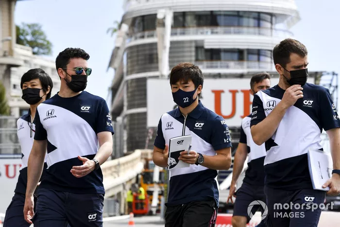 Yuki Tsunoda, AlphaTauri, walks the track with his team