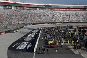 Drivers, crew and fans stand for the national anthem
