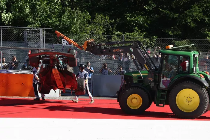 Los oficiales de pista retiran el coche dañado de George Russell, Mercedes W13, tras un trompo en la Q3