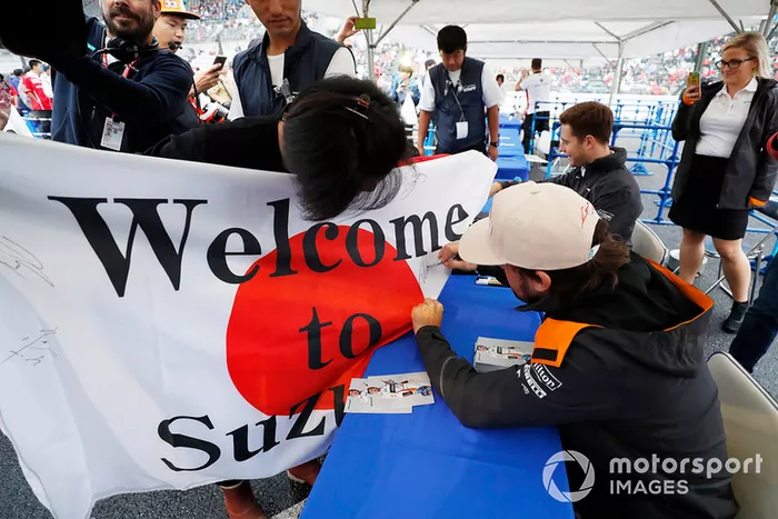 Fernando Alonso, McLaren, Firma una enorme bandera japonesa con un mensaje de los fans.