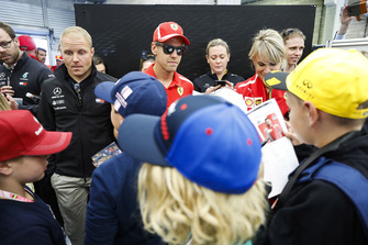 Valtteri Bottas, Mercedes AMG F1, and Sebastian Vettel, Ferrari, sign autographs for children