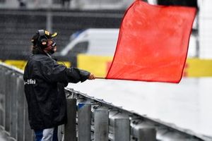 A marshal waves a red flag as the session is stopped due to inclement weather