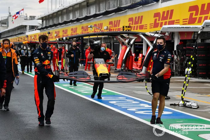 Los mecánicos se apresuran a reemplazar el alerón delantero dañado de Max Verstappen, Red Bull Racing RB16