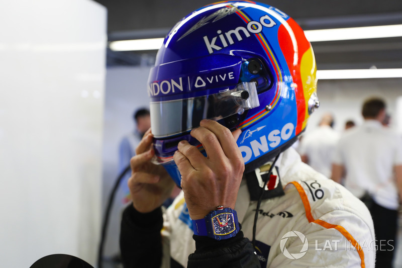 Fernando Alonso, McLaren, adjusts his helmet