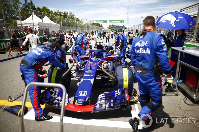 The Pierre Gasly Toro Rosso STR13 is attended to by mechanics on the grid