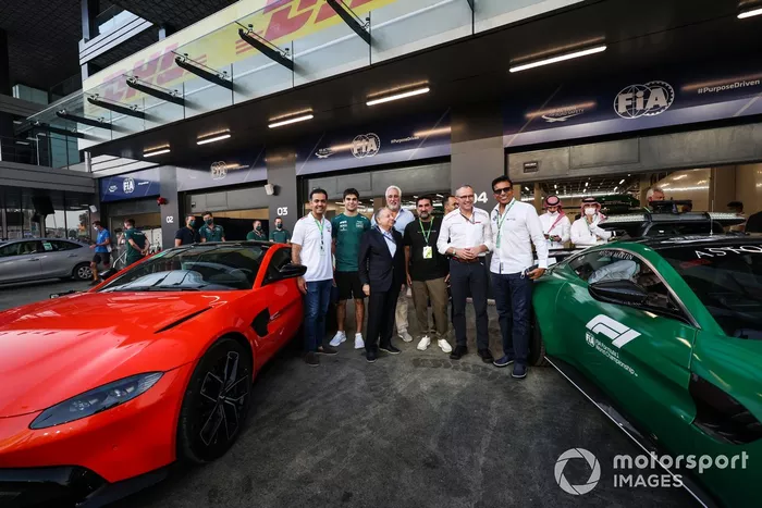 Lance Stroll, Aston Martin, Jean Todt, Presidente de la FIA, Lawrence Stroll, Propietario de Aston Martin F1, Stefano Domenicali, Director General de la Fórmula 1 y otros dignatarios posan con un par de coches Aston Martin Vantage