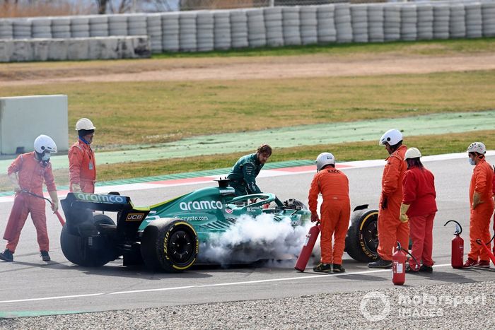 Oficiales de pista asisten a Sebastian Vettel, Aston Martin AMR22, después de que un fallo técnico produzca humo