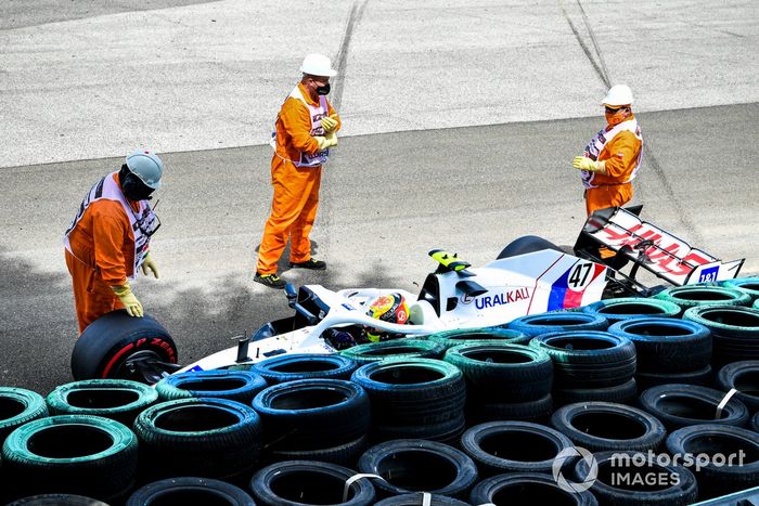 Los oficiales de pista asisten a Mick Schumacher, Haas VF-21, tras su accidente en la FP3