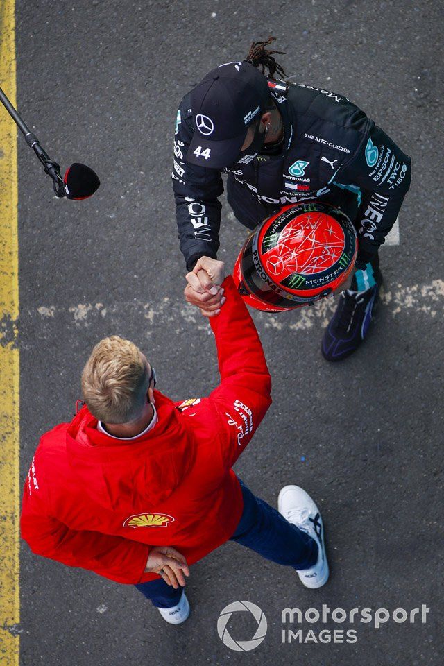 Mick Schumacher, Alfa Romeo Racing, entrega al ganador de la carrera Lewis Hamilton, Mercedes-AMG F1, el casco Mercedes de su padre, Michael Schumacher de 2012