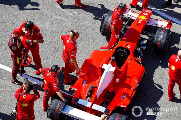 Mick Schumacher is briefed by Ferrari personnel prior to driving his fathers championship winning Ferrari F2004