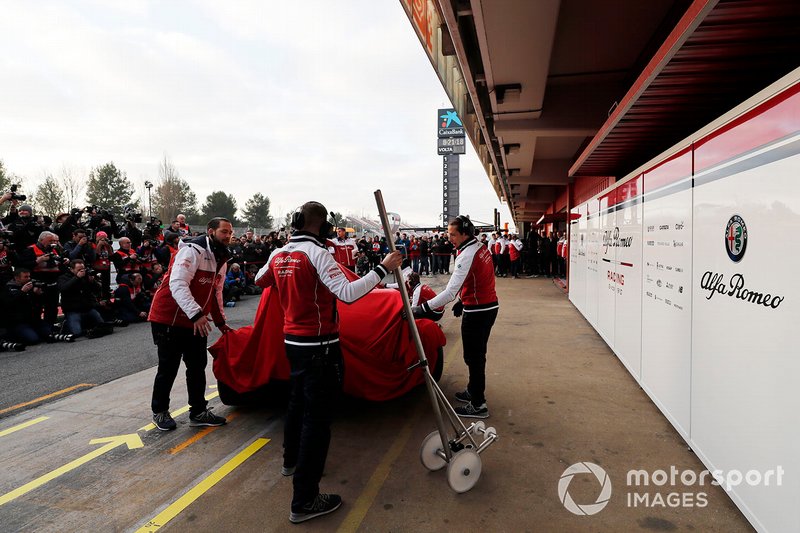 Meccanici Alfa Romeo Racing con la nuova Alfa Romeo Racing C38, sotto al telo