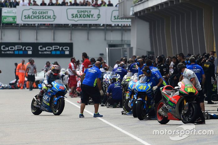 Los mecánicos preparados en boxes para hacer el cambio de moto