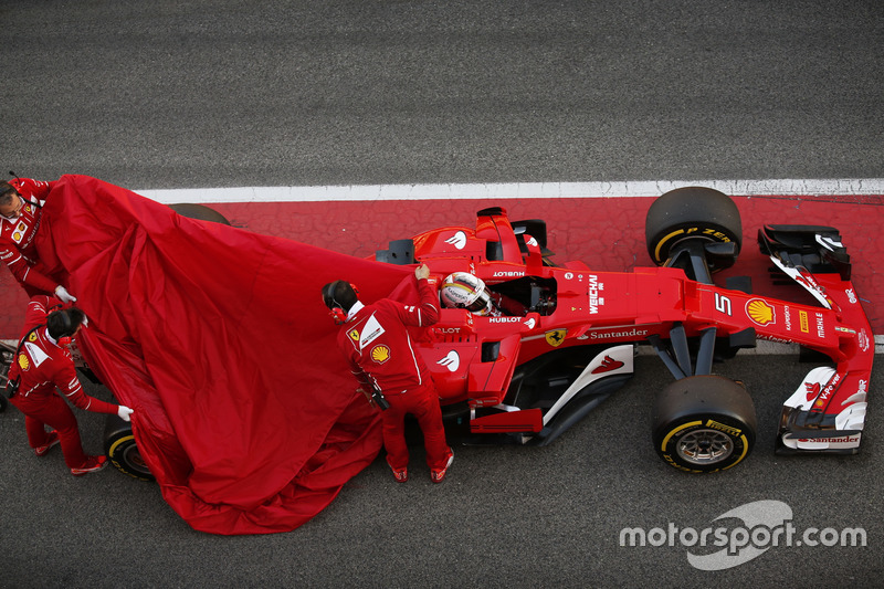 Sebastian Vettel, Ferrari SF70H, kembali ke pit saat mekanik menutup bagian belakang mobil