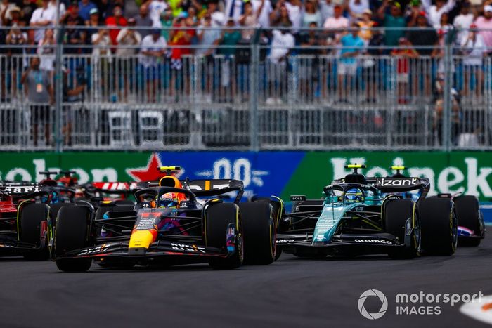 Sergio Pérez, Red Bull Racing RB19, Fernando Alonso, Aston Martin AMR23, el resto de la parrilla en la primera vuelta.