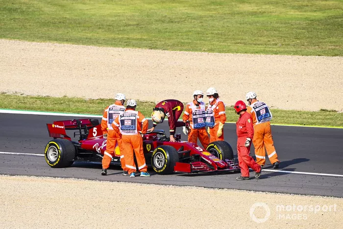 Los oficiales asisten mientras Sebastian Vettel, Ferrari SF1000 se detiene en la pista