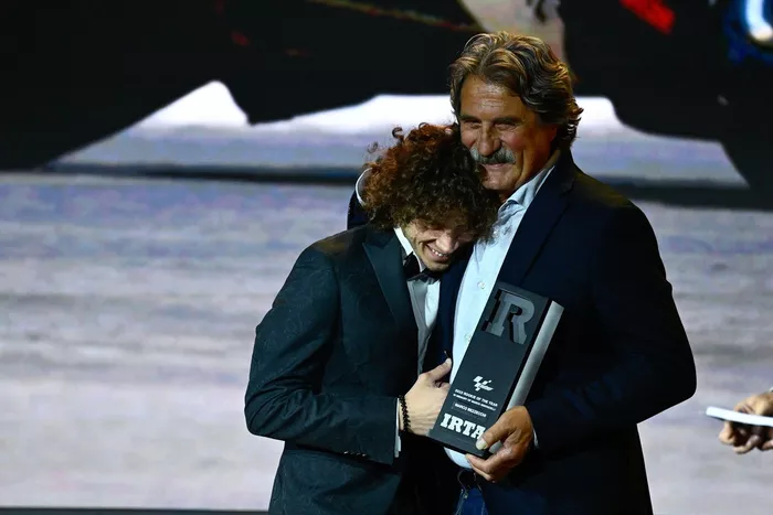 Marco Bezzecchi, equipo VR46 Racing, recogiendo el premio de mejor debutante del año en MotoGP 2022 de manos de Paolo Simoncelli