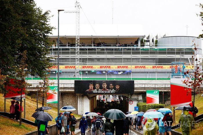 Los aficionados se refugian de la lluvia