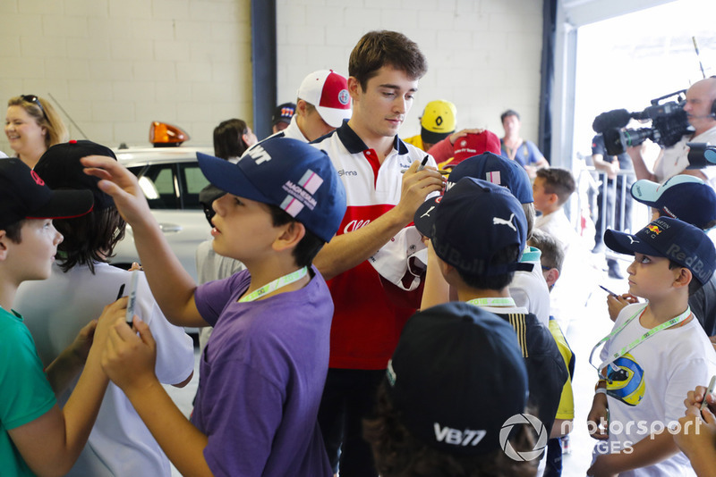 Charles Leclerc, Sauber, signs autographs for young fans.