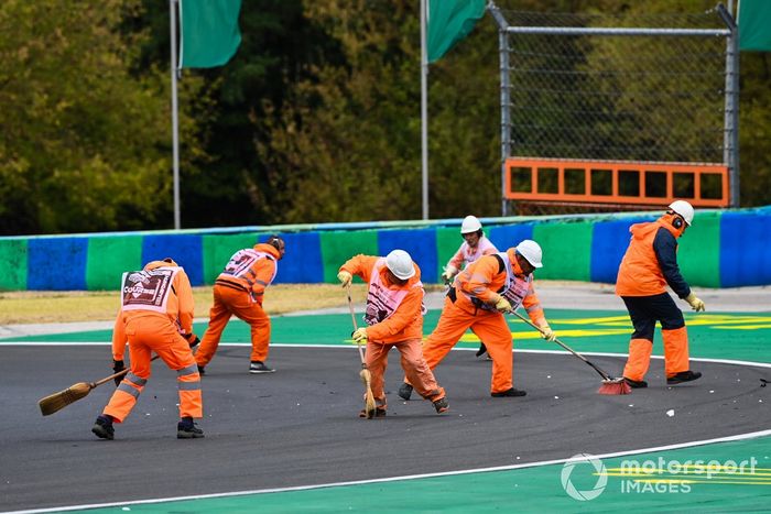 Oficiales de pista  barren los restos del circuito