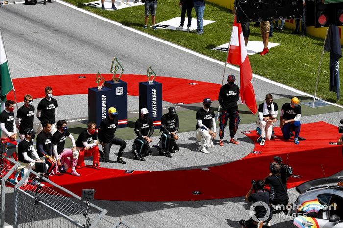 Los pilotos se arrodillan en la parrilla antes de la salida.