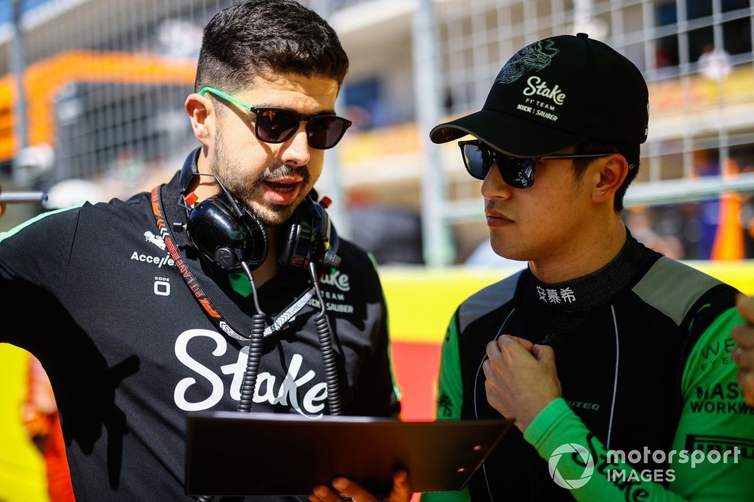 Zhou Guanyu, da Stake F1 Team KICK Sauber, na grelha de partida com um engenheiro
