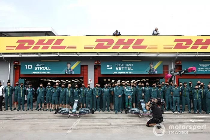 El equipo Aston Martin se pone de pie para una foto de equipo en el pit lane