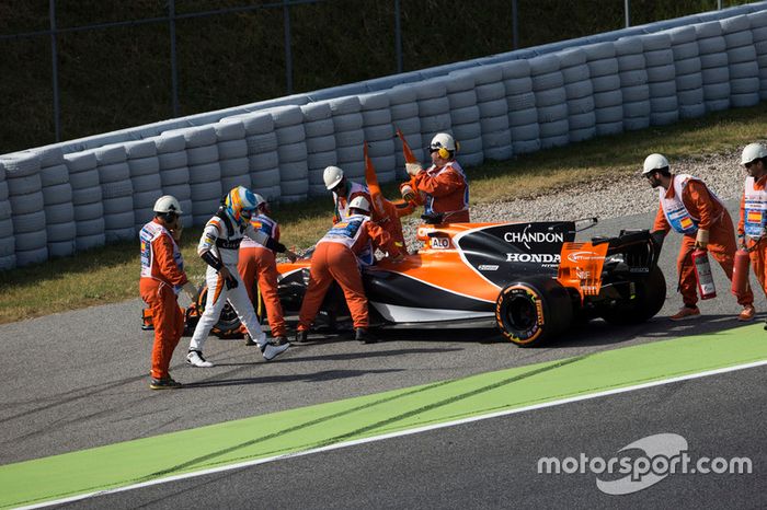 Oficiales de pista asisten a Fernando Alonso, McLaren MCL32 al tener con problemas de motor