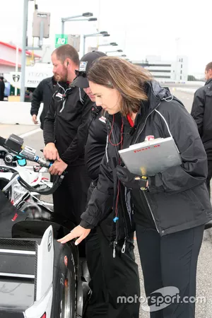 Cara Adams, ingeniero jefe para el Firestone Racing, inspecciona un neumático en Josef Newgarden, co