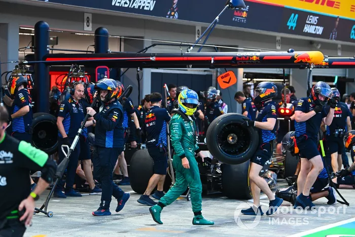 Fernando Alonso, Aston Martin F1 Team, pasa a pie mientras Sergio Pérez, Red Bull Racing RB20, hace una parada en boxes durante la FP3