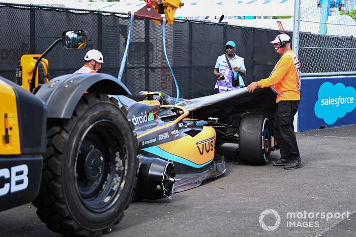 Los oficiales retiran el coche dañado de Lando Norris, McLaren MCL36