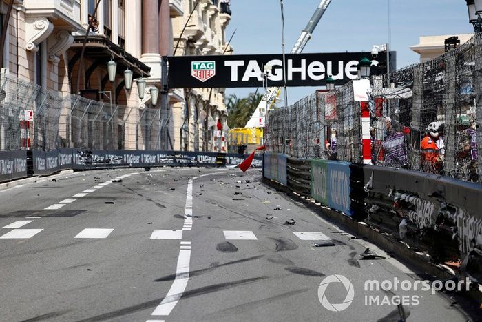 Escombros en la pista mientras los comisarios ondean las banderas rojas debido a un accidente en la primera vuelta.