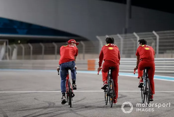 Charles Leclerc, Ferrari conduce una bicicleta por la pista con miembros del equipo Ferrari