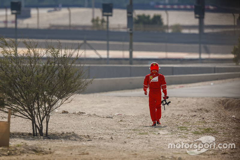 Kimi Raikkonen, Ferrari, walks back to the garage