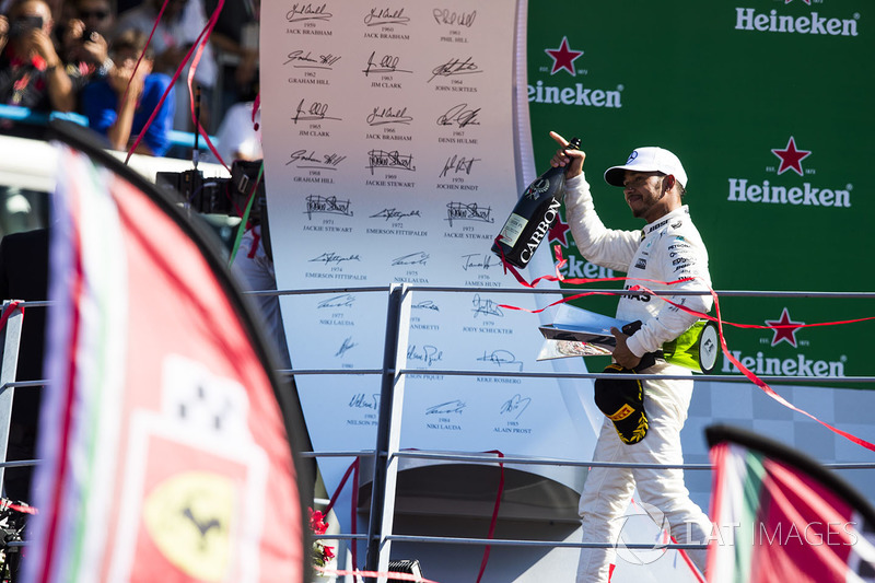 Race winner Lewis Hamilton, Mercedes AMG F1, leaves the podium, his trophy and Champagne bottle