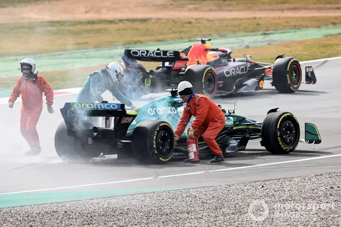 Marshals assist Sebastian Vettel, Aston Martin AMR22, after a technical failure results in smoke