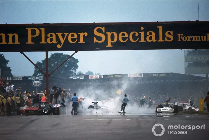 Trabajos de limpieza después del accidente en la primera vuelta. El Ford Ford March 731 de Roger Williamson a la izquierda, mientras que el Ford Brabham BT42 de Wilson Fittipaldi dañado y Graham Hill detiene su Ford Shadow SN1