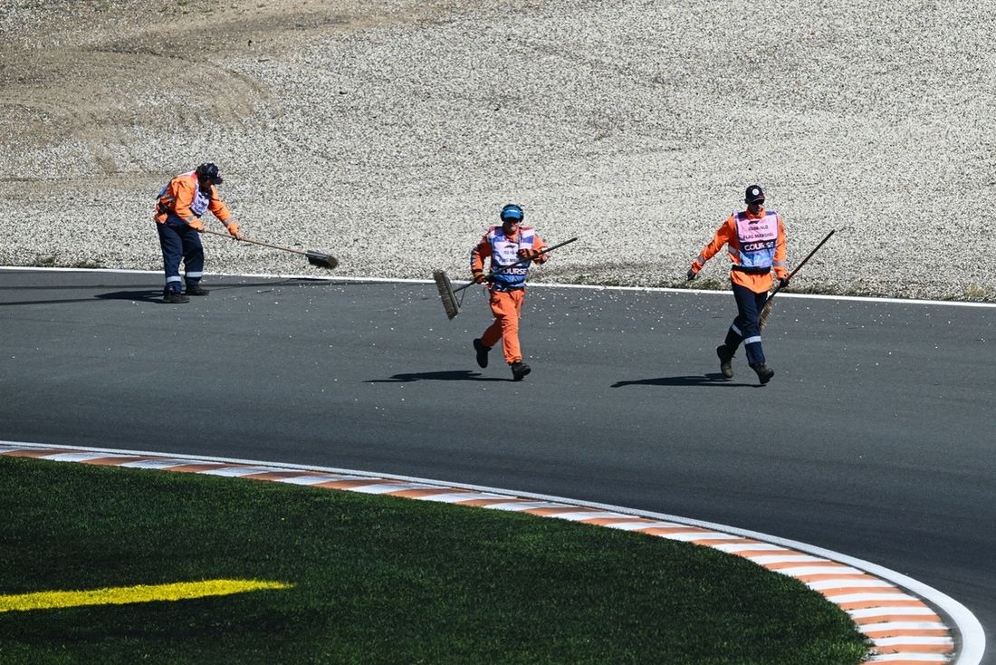 Los comisarios limpian la pista durante la sesión de clasificación del Gran Premio de Holanda de Fórmula Uno en el circuito de Zandvoort, al oeste de Holanda, el 30 de agosto de 2025. (Foto de NICOLAS TUCAT / AFP)