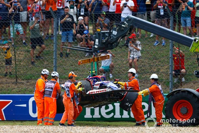 Los comisarios retiran del circuito el coche dañado de Yuki Tsunoda, RB F1 Team VCARB 01.