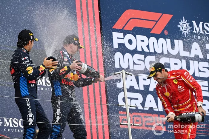 Sergio Perez, Red Bull Racing, 2e position, Max Verstappen, Red Bull Racing, 1re position, et Carlos Sainz, Scuderia Ferrari, 3e position, arrosent le champagne pour célébrer. 