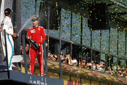 Le deuxième, Lewis Hamilton, Mercedes AMG F1, et le vainqueur Sebastian Vettel, Ferrari, avec du champagne sur le podium