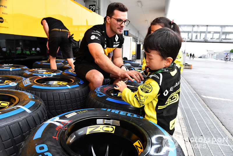 Renault Sport F1 Team mechanic with Pirelli tyres and young fans