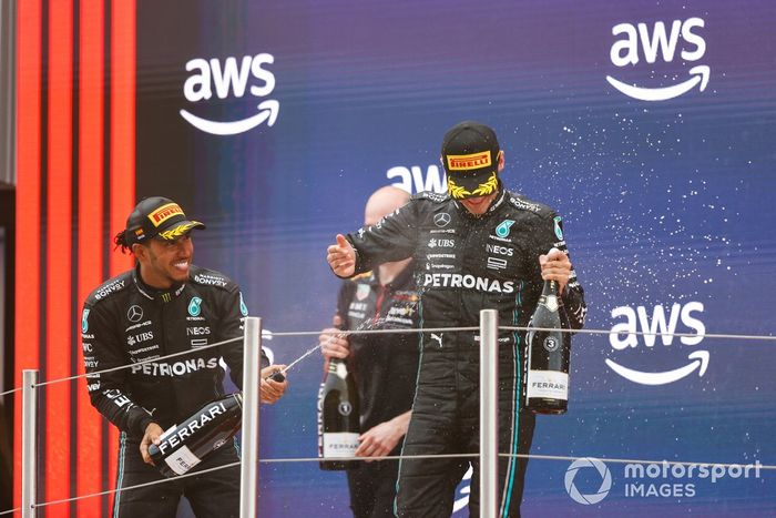 Lewis Hamilton, Mercedes-AMG, 2ª posición, George Russell, Mercedes-AMG, 3ª posición, celebran en el podio con champán